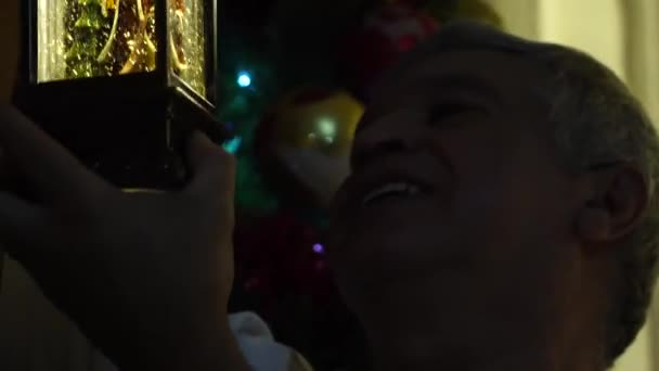 Мужчина ищет рождественское украшение — стоковое видео