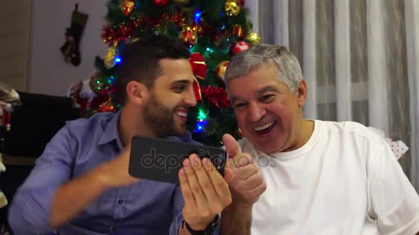 Padre e hijo teniendo un video chat el día de Navidad — Vídeos de Stock