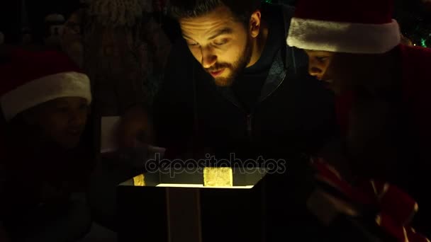 Família abrindo uma caixa de presente mágica — Vídeo de Stock