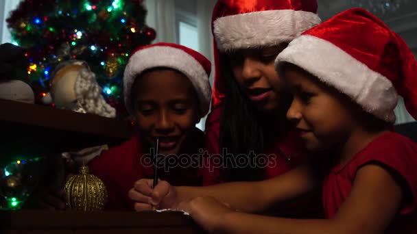 Menina escrevendo carta de Natal para Papai Noel com sua família — Vídeo de Stock