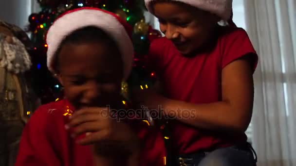 Niños jugando con luces de Navidad — Vídeo de stock