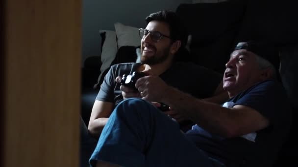 Отец и сын играют в видеоигры — стоковое видео