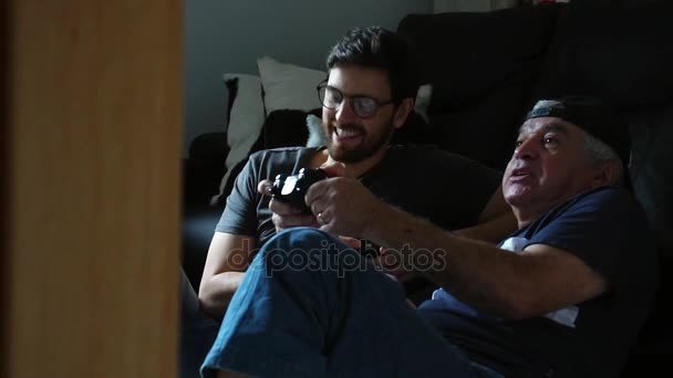 Отец и сын играют в видеоигры — стоковое видео