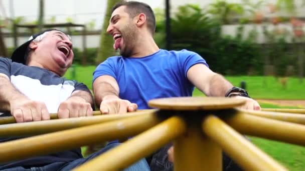 Vater und Sohn spielen auf Kreisverkehr — Stockvideo