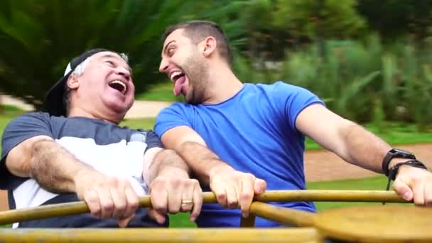 Vater und Sohn spielen auf Kreisverkehr — Stockvideo