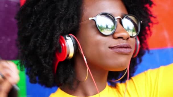 Linda Chica Escuchando Música Con Sus Auriculares Con Fondo Colorido — Vídeos de Stock