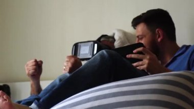 Arkadaş/baba ve oğul aşağı yalan ve Vr Googles ve Tablet ile eğleniyor