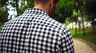 Ağır çekimde parkta yürüyen adam