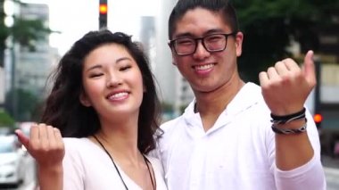 Genç Asyalı çift kişi gelmek davet etme