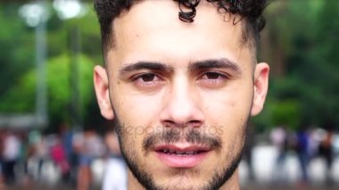 Kameraya bakarak ciddi genç adam