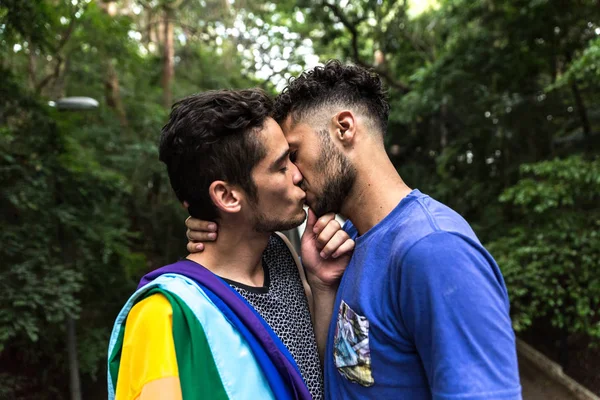Gay Pareja Besos Con Arco Iris Bandera Parque — Foto de Stock