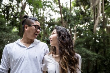 Parkta yürüyen Asyalı çift.