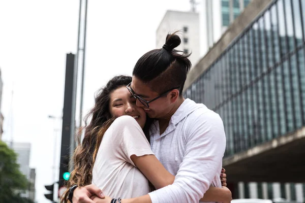 Young Asian Couple Embracing in Paulista Avenue, Sao Paulo, Brazil