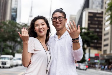 Genç Asyalı çift kişi gelmek davet etme