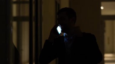 Yalnız karanlık ofisinde telefon kullanarak iş adamı