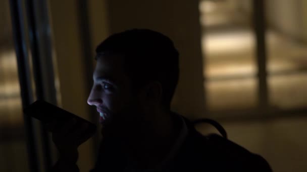 Homme d'affaires utilisant mobile seul dans le bureau sombre 