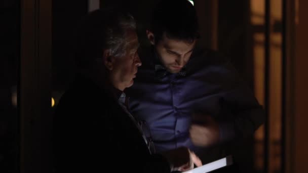 Deux collègues discutent la nuit sur le bureau 