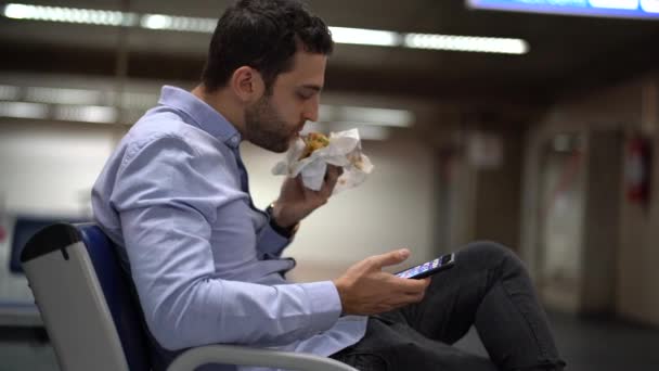 男は空港でサンドイッチを食べて — ストック動画