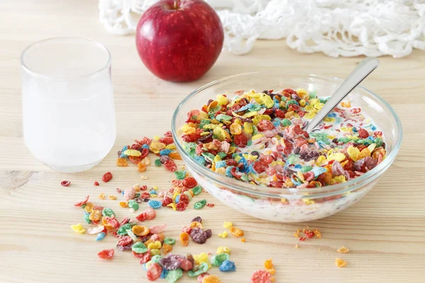 Kids healthy quick funny breakfast. Colorful rice cereal with milk and red apple for kids.