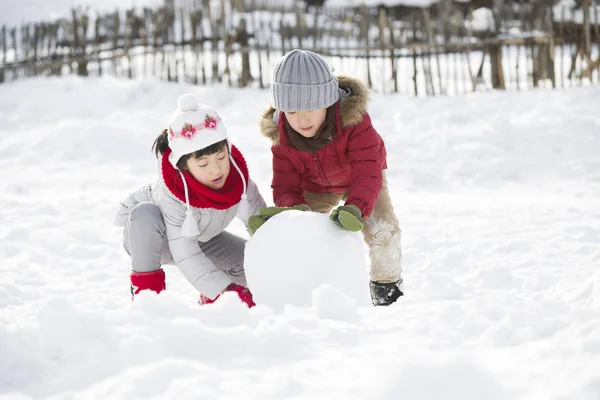 Chinese Children Rolling Snowball Outdoors — Stock Photo, Image