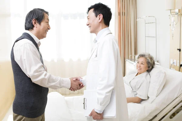 Homem Chinês Apertando Mãos Com Médico Com Mulher Cama Hospital — Fotografia de Stock