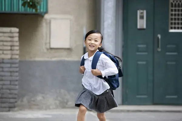 学校の建物から実行している中国の女の子 — ストック写真