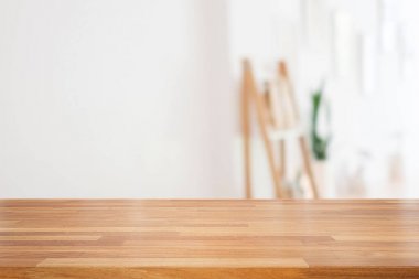 Ahşap masa üstü boş ve modern beyaz oturma odası gösteren ağaç ve çerçeve, hazır ürün montaj için bulanıklık