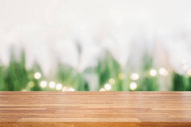 Boş ahşap masa ve yeşil bitkiler ve ışık bokeh backg daire
