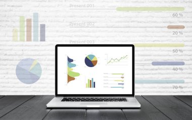 Grafikler ve grafik renkli grafik gösteren ahşap masa üstünde laptop