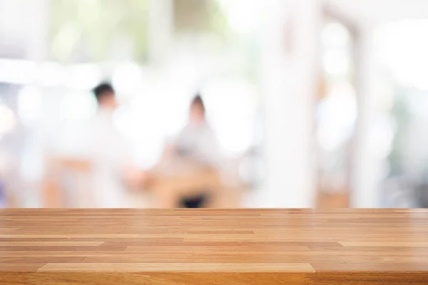 Lege houten tafel en wazig mensen in café achtergrond, produc — Stockfoto