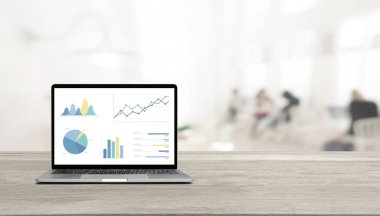 Ahşap masadaki modern dizüstü bilgisayar grafikleri ve grafikleri O 'ya karşı gösteriyor