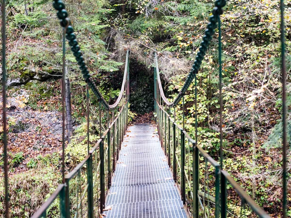 Perspectiva decrescente de metal suspensão passarela sobre rive — Fotografia de Stock