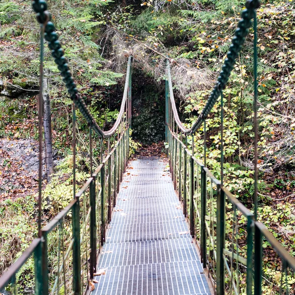 Perspectiva decrescente de metal suspensão passarela sobre rive — Fotografia de Stock