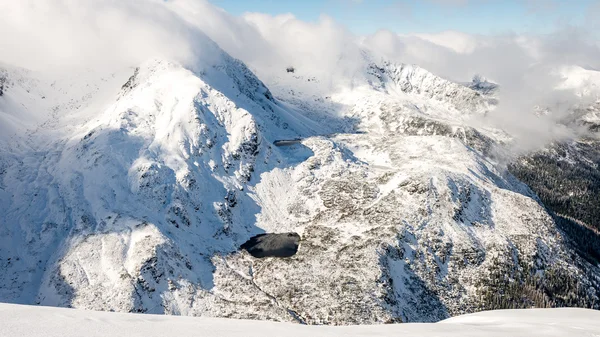 Sommets de montagne en hiver couverts de neige avec un soleil éclatant et bleu — Photo