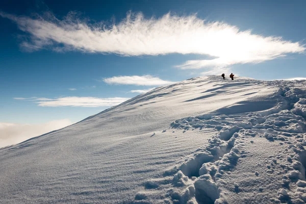 Turistas disfrutando de altas montañas en la nieve en un día soleado — Foto de Stock