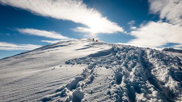 Touristes profitant de hautes montagnes dans la neige par une journée ensoleillée — Photo