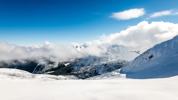 Cumes de montanha no inverno coberto de neve com sol brilhante e azul — Fotografia de Stock