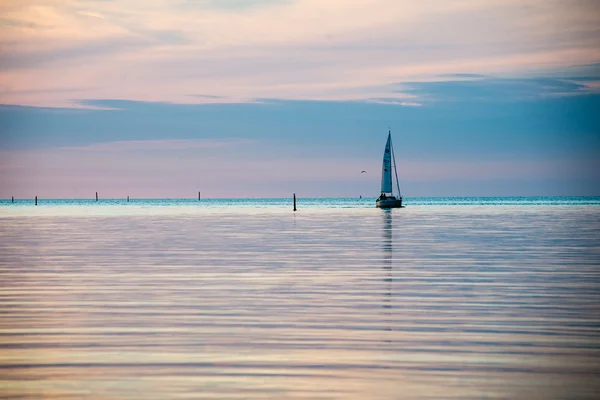 Reflections in the calm lake water with small boat — Stock Photo, Image