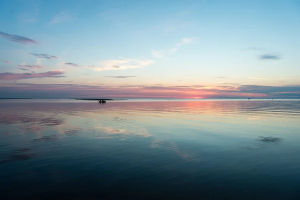 Reflexiones en el tranquilo agua del lago con un pequeño barco —  Fotos de Stock