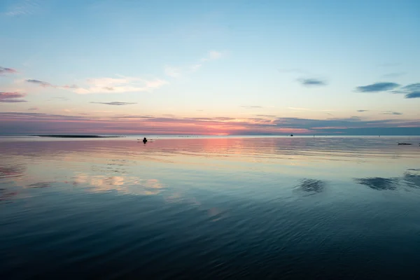 Riflessioni nella calma acqua del lago con piccola barca — Foto Stock