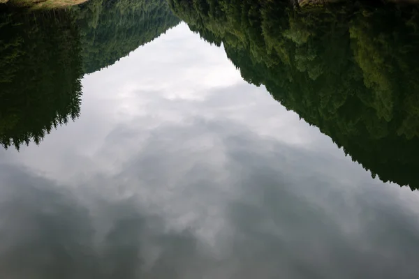 Reflections in the calm lake water — Stock Photo, Image