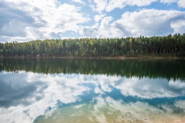Yaz aylarında bulutların yansımaları ile sakin göl