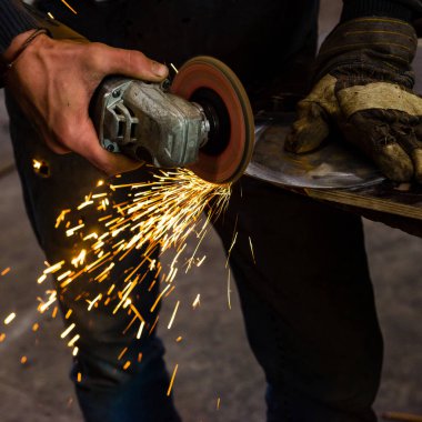 El ile örs üzerinde erimiş metal dövme demirci