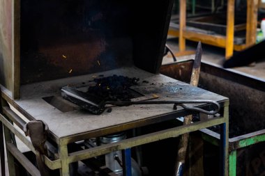 El ile örs üzerinde erimiş metal dövme demirci