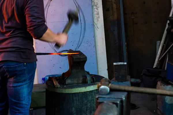 The blacksmith manually forging the molten metal on the anvil — Stock Photo, Image