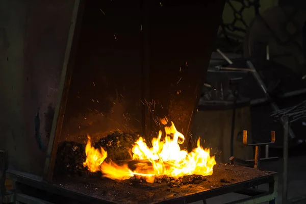 Кузнец разжигает пламя в кузнице — стоковое фото