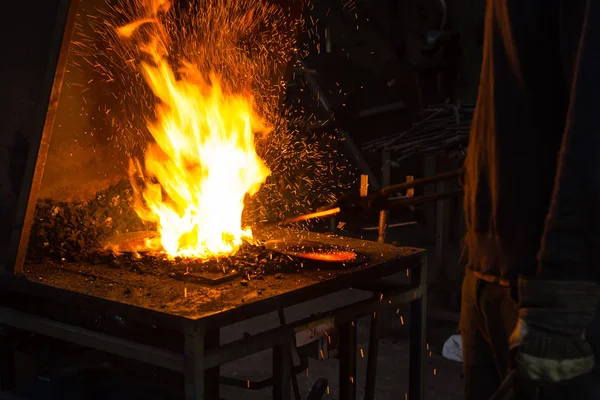 Кузнец разжигает пламя в кузнице — стоковое фото