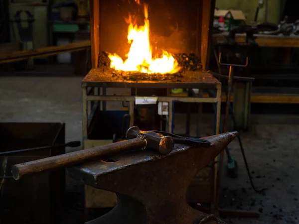 O ferreiro forjando manualmente o metal fundido na bigorna — Fotografia de Stock