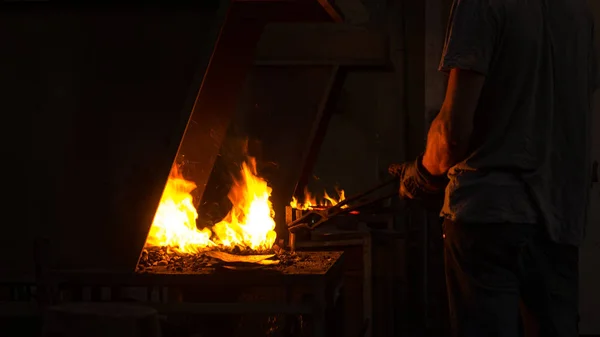 The blacksmith manually forging the molten metal on the anvil — Stock Photo, Image