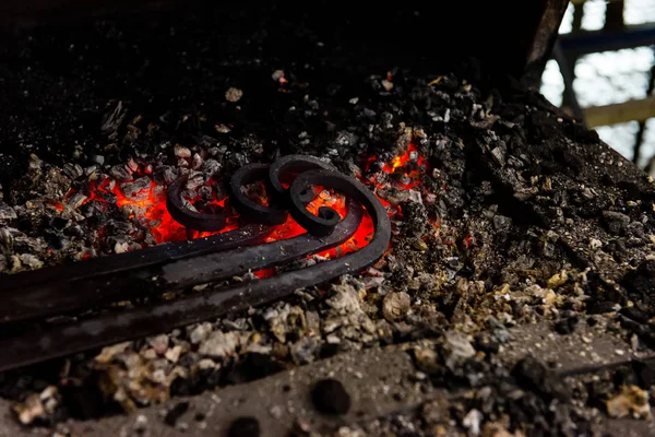 Кузнец вручную ковал расплавленный металл на наковальне — стоковое фото